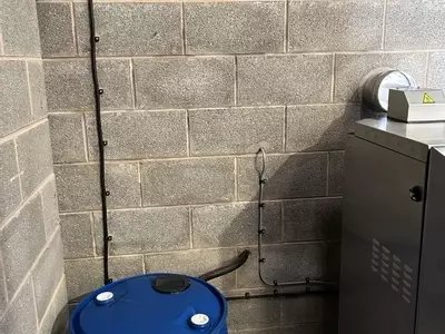 Water barrel and electrical supply installed to feed a Nilfisk SH Truck static hot pressure washer inside a farm wash bay in Twycross.